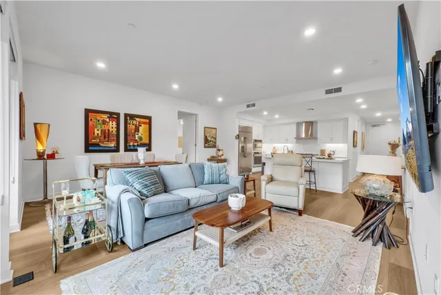 a living room with furniture and a view of kitchen
