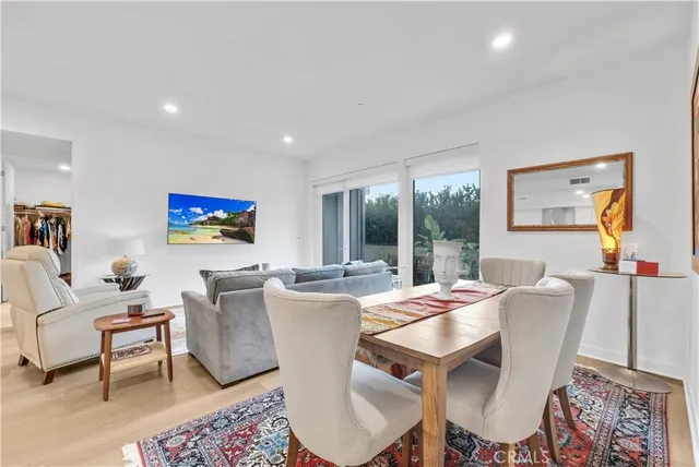 a view of a dining room with furniture a rug and wooden floor