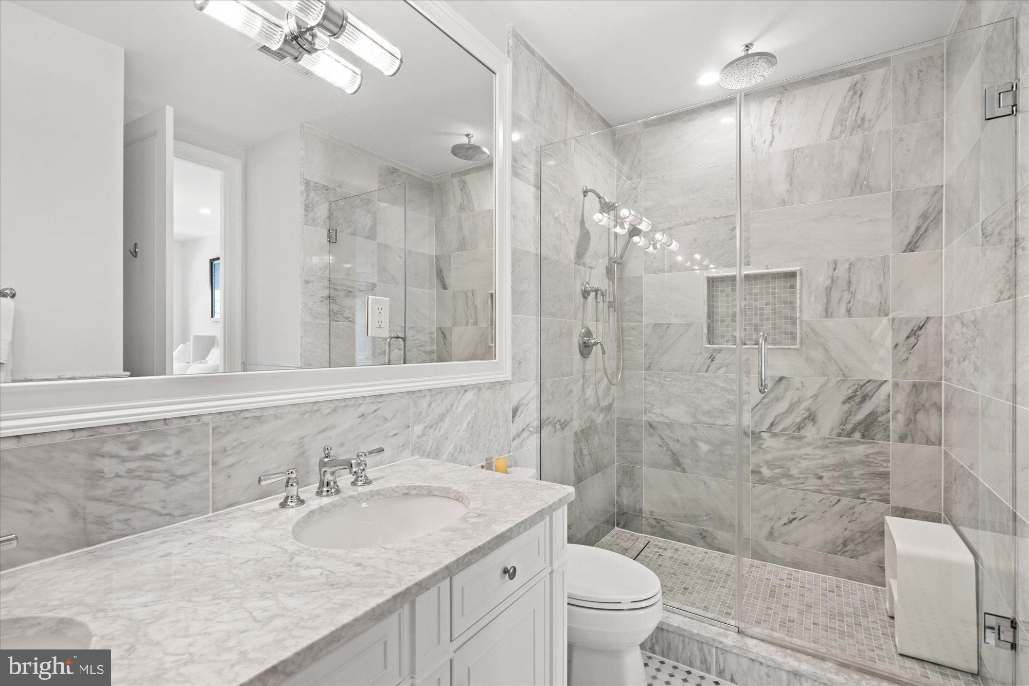 2610 Garfield Street Northwest Washington, DC 20008 - Photo 24 of 51 a bathroom with a granite countertop sink a toilet a mirror a shower and vanity
