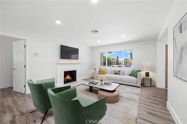 a living room with furniture a fireplace and a wooden floor