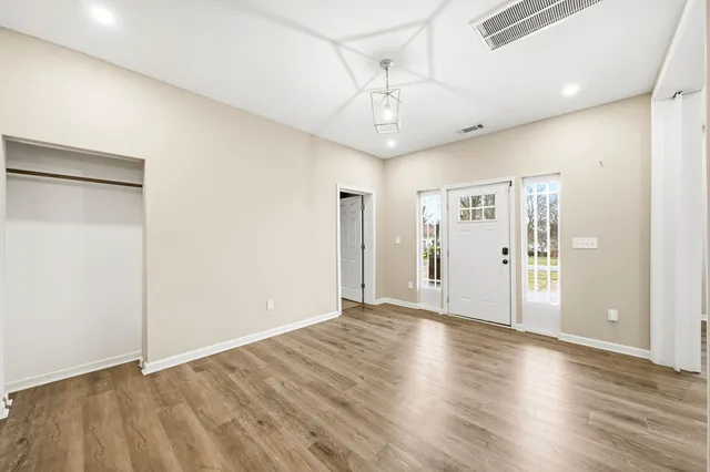 a view of an empty room with wooden floor
