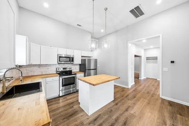 a large kitchen with cabinets and stainless steel appliances
