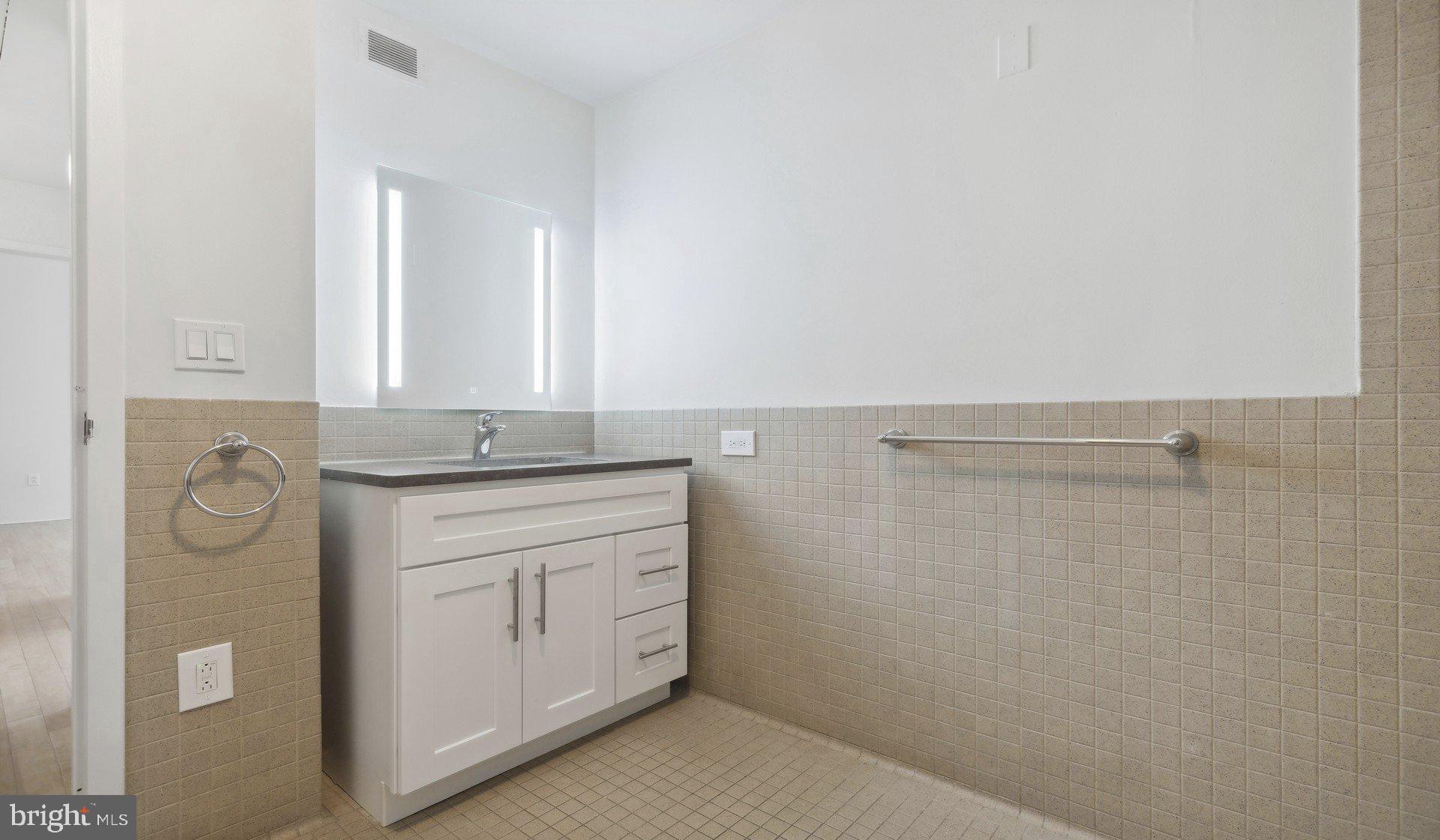 2300 Walnut Street, Unit 1B232 Philadelphia, PA 19103 - Photo 7 of 30 a bathroom with a granite countertop sink and a mirror