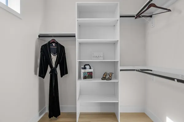 a view of walk in closet with clothes and shoes