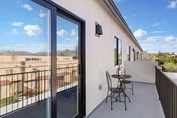 a view of a porch with furniture and floor to ceiling window