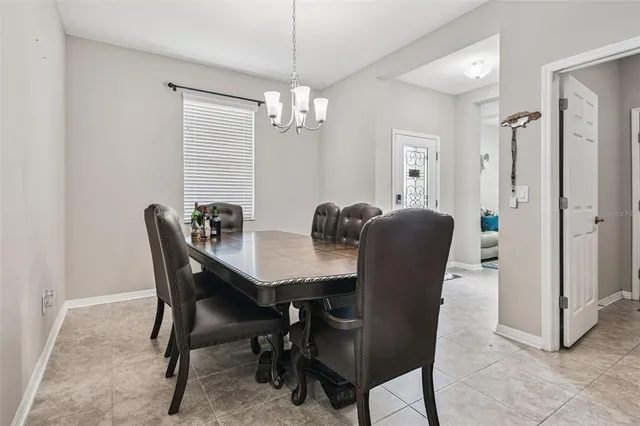 a kitchen with stainless steel appliances kitchen island granite countertop a stove a sink a microwave a dining table and chairs