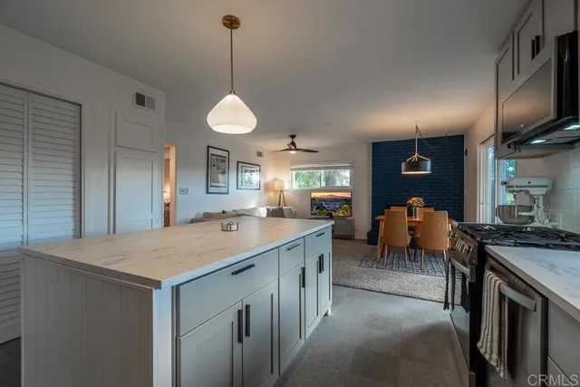 a kitchen with stainless steel appliances granite countertop a sink a stove and a wooden floors