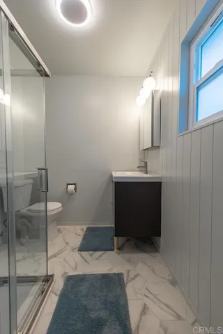 a bathroom with a sink a toilet and a large mirror
