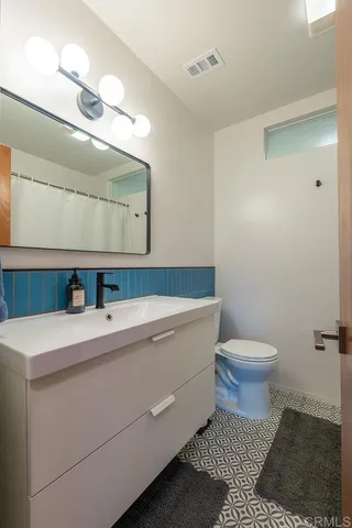 a bathroom with a sink a toilet and mirror