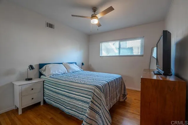 a bedroom with a bed and a flat tv screen on the dresser