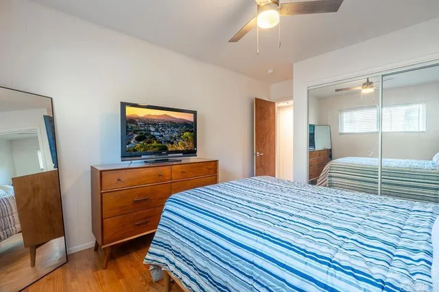 a bedroom with a bed window and a flat screen tv