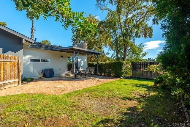 a view of a house with backyard and sitting area