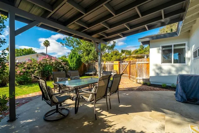 a view of a porch with furniture and a yard