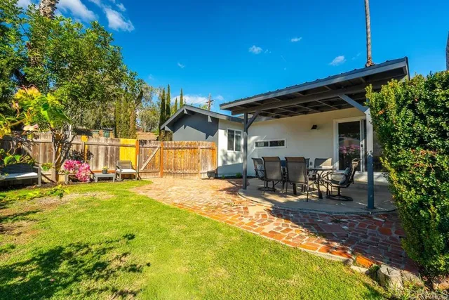 a view of a house with backyard and sitting area