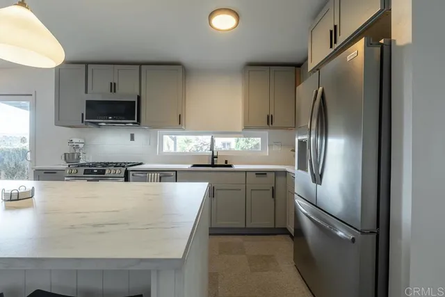 a kitchen with kitchen island a counter top space stainless steel appliances and cabinets