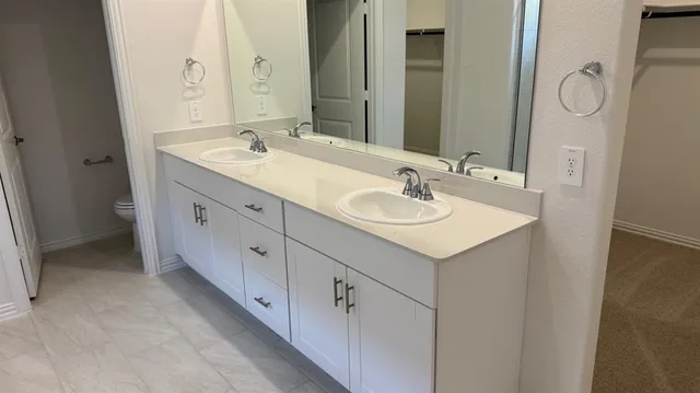 a spacious bathroom with a granite countertop sink and a mirror
