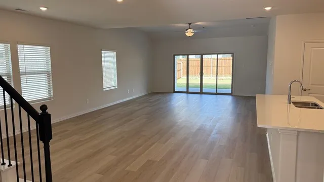 a view of a livingroom with wooden floor and staircase