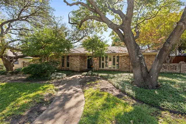 a view of a house with a tree in the yard