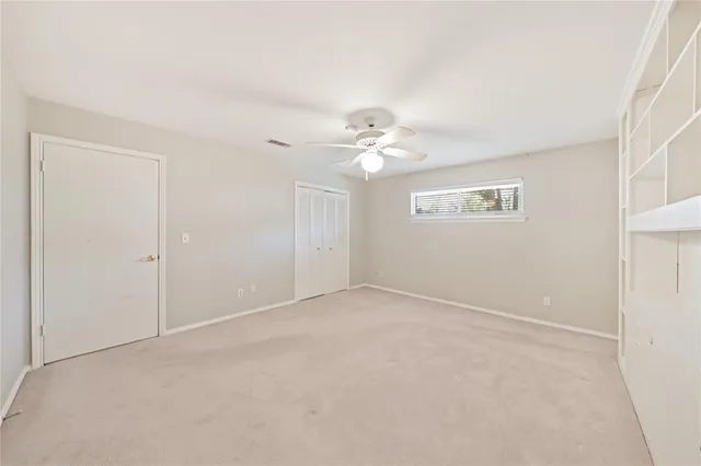 a view of an empty room with a chandelier fan