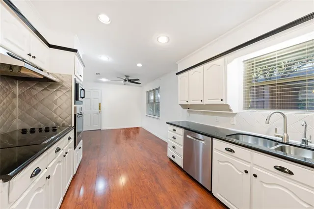 a kitchen with granite countertop wooden cabinets and white appliances