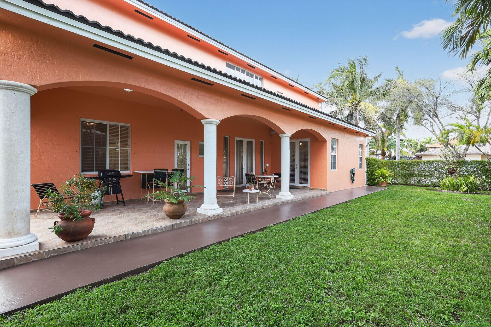 a front view of a house with patio and garden