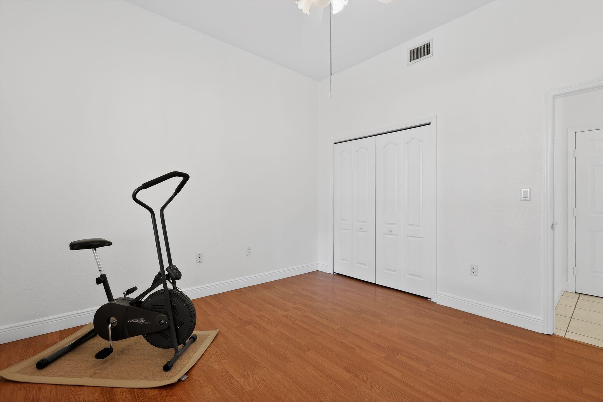16613 Northwest 77th Path Miami Lakes, FL 33016 - Photo 37 of 41 a room with wooden floor and gym equipment
