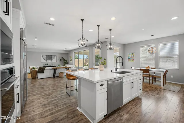 a kitchen with stainless steel appliances a sink stove and cabinets