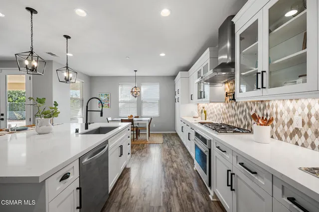 a dining room with wooden floor a chandelier a wooden table and chairs
