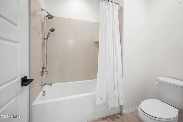 a bathroom with a sink a toilet and a large mirror