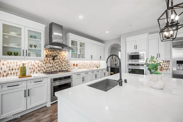 a kitchen with a sink a stove and cabinets
