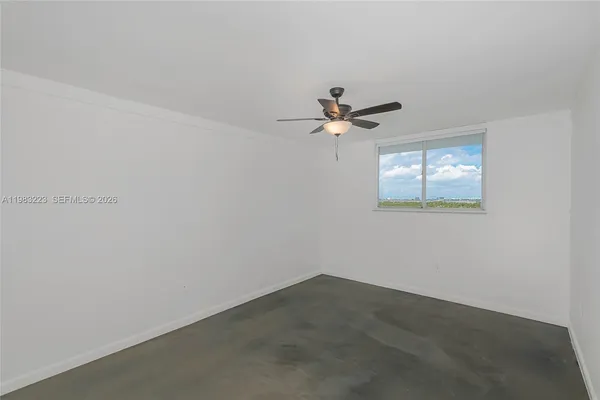 an empty room with a window and a ceiling fan