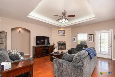 a living room with furniture a flat screen tv and a window