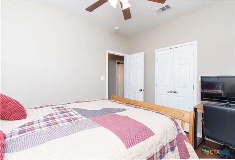 a bedroom with a bed and a flat screen tv