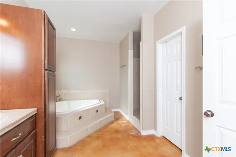 a bathroom with a tub sink and mirror