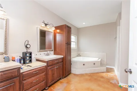 a bathroom with a tub sink and mirror