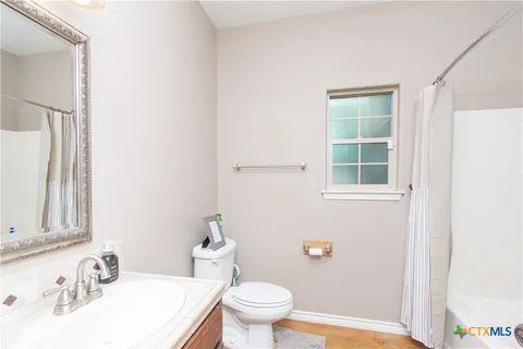 a bathroom with a sink a toilet and a window