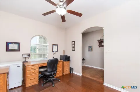 a view of a workspace with furniture and a window
