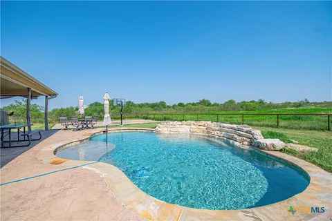 a view of a swimming pool with a yard and sitting area