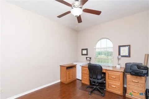 a view of a workspace with furniture and a window