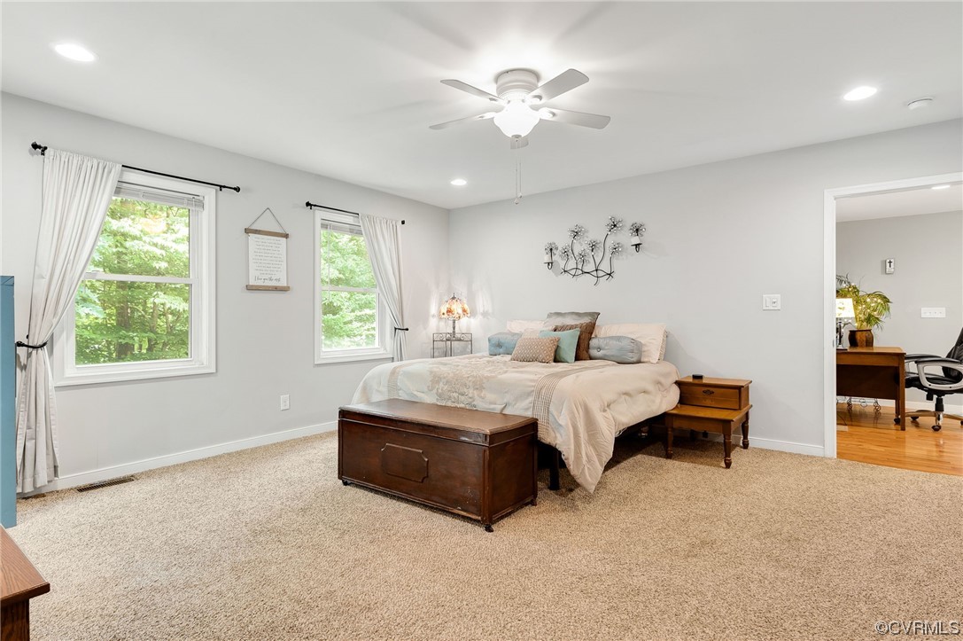 3928 Whitehall Road Sandy Hook, VA 23153 - Photo 16 of 33 a spacious bedroom with a bed and a chandelier