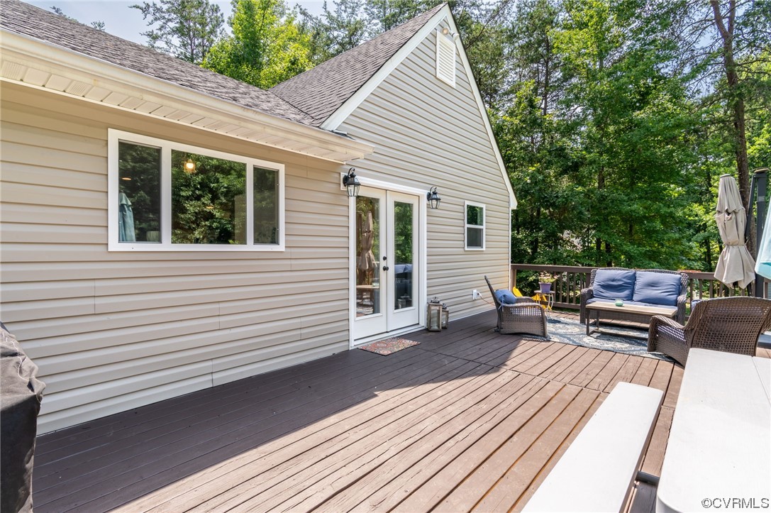 3928 Whitehall Road Sandy Hook, VA 23153 - Photo 27 of 33 a view of a deck with chairs a barbeque with wooden floor and fence next to a yard