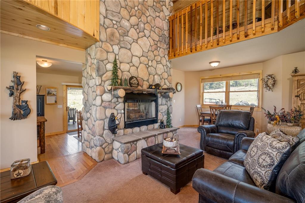 177 East Longbow Drive Como, CO 80456 - Photo 2 of 27 a living room with furniture a fireplace and a flat screen tv