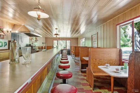 an aerial view of residential house with yard and outdoor seating