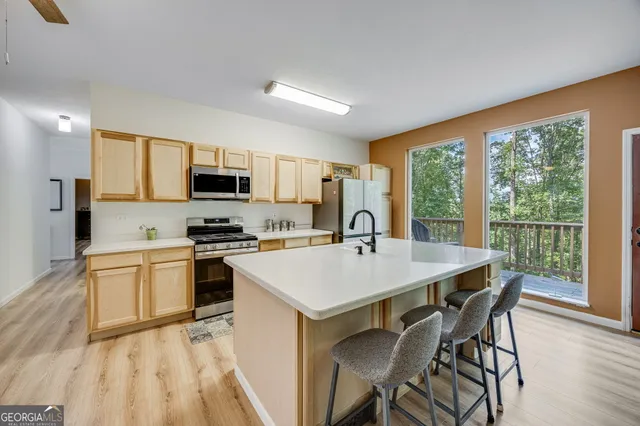 a kitchen with a stove a sink a microwave a dining table and chairs