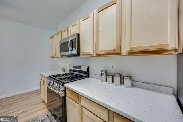 a kitchen with stainless steel appliances a sink a stove and cabinets