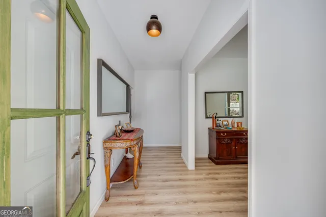 a view of a hallway with wooden floor and entryway