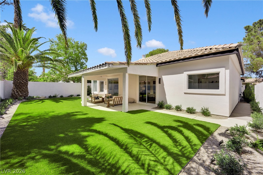 8981 Rivers Edge Drive Las Vegas, NV 89117 - Photo 46 of 69 A private outdoor living space offers a covered patio and verdant lawn, ideal for al fresco enjoyment.