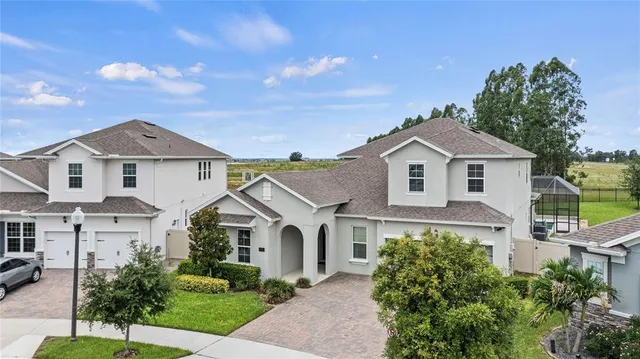 a front view of a house with a yard and potted plants