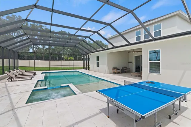 an aerial view of residential house with outdoor space and lake view in back