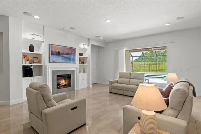 a living room with furniture a fireplace and a chandelier
